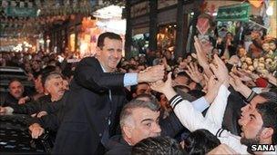 Bashar al-Assad greets crowds in Damascus, 15 February (Sana handout via AFP)