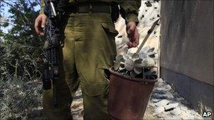 Israeli soldier gathers mortars fired on Saturday