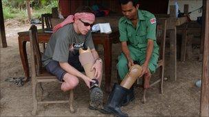 Stuart Hughes with a fellow landmine victim in Cambodia