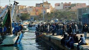 North African migrants wait at the port in Lampedusa, Italy (27 March 2011)