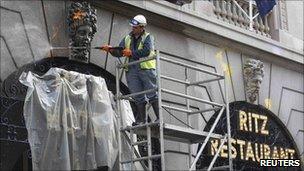 A worker removes paint from the facade of the Ritz Hotel after riots, pictured 28 March