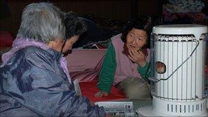 Elderly women sit around the only space heater in an evacuation centre in Iwate prefecture in northeastern Japan on 29 March 2011