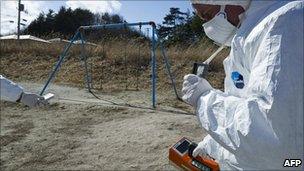 A Greenpeace member holds up a Geiger counter to monitor radioactivity levels at Iitate village, Japan, 27 March