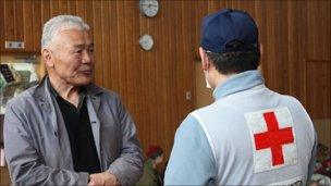 Ken Minato (L), a fisherman in the community of Yamada, Iwate prefecture, talks with a volunteer from the Japanese Red Cross Society. Minato now lives in an evacuation centre with more than 260 of his neighbours after their homes were destroyed by the tsunami. Photo: Owaki Mutsuhiko / Japanese Red Cross Society