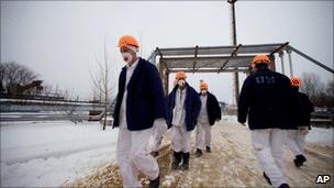 In this Thursday Feb. 24, 2011 picture workers walks in protective clothing on the grounds of the Chernobyl nuclear power plant in Ukraine. They are starting work on a shelter to cover the building where a reactor exploded