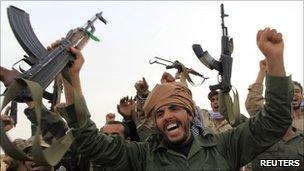 Libyan government soldiers celebrate at the west gate of town Ajdabiya, March 16, 2011