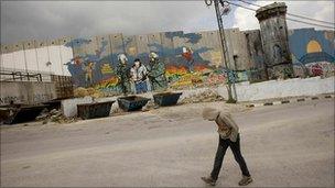 Palestinian boy walks by separation barrier in Aida Refugee Camp, near Bethlehem.