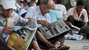 Burmese men reading newspapers