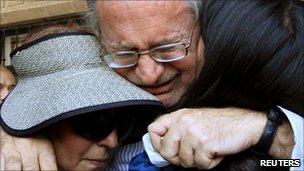 Mexican writer Javier Sicilia cries as he hugs family members after the death of his son