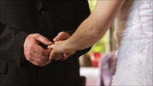 Man places wedding ring on bride's finger