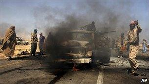 Libyan rebels inspect two destroyed military vehicles of pro-Gaddafi forces near Brega, Libya, 5 April 2011