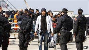 Tunisian immigrants disembark from a ferry boat during evacuation from Lampedusa to a reception centre in Manduria on April 1, 2011