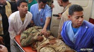 Medical staff tend to a rebel fighter with a shrapnel wound on his leg, after he was brought in from western Ajdabiya, April 9, 2011