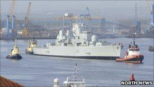 HMS Bristol being guided out of the Tyne