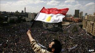 An Egyptian protester waves his national flag as tens of thousands gather for a demonstration at Cairo's Tahrir Square on April 8, 2011