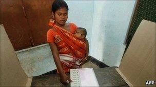 A woman casts her vote in a polling station in Assam on 4 April 2011