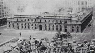 Soldiers supporting the coup led by Gen. Augusto Pinochet take cover as bombs are dropped on the Presidential Palace of La Moneda in this 11 Sept 1973 file photo