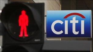 Citigroup sign in Singapore next to a red man pedestrian crossing light