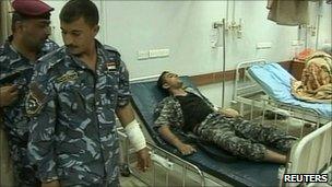 Injured policeman in a Baghdad hospital after an attack on the Sacred Heart church (24 April 2011)