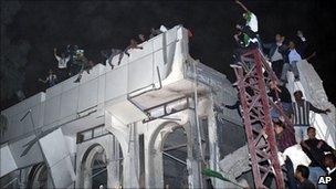 Supporters of Col Gaddafi on a bomb-damaged building. 25 April 2011