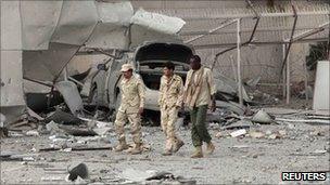 Libyan soldiers walk through ruins in Tripoli