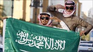 Saudi Arabian men carry a national flag during celebrations in support for the King, Riyadh, 18 March, 2011.