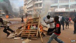 Rioters fuel a burning barricade during riots in Kampala, Uganda, on 29 April 2011