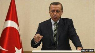 Turkey's Prime Minister Recep Tayyip Erdogan addresses the media as he stands by Turkey's national flag, 3 May 2011