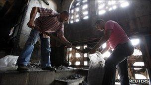 Christians clean up a church damaged by fire in Cairo, Egypt (8 May 2011)