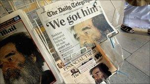 Newspapers on a stand in London reporting the capture of former Iraqi leader Saddam Hussein in 2003.