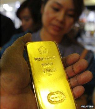 Man holding a gold bar at an Asian trade fair (Image: Reuters)