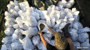 A woman ties sandbags together in Stephensville, Louisiana, on 15 May 2011