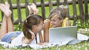 Girls chatting and using a laptop