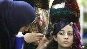 A Palestinian hairstylist works on a hair style inspired by the Palestinian political reconciliation between Hamas and Fatah on 12 May 2011 in Gaza City