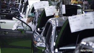 A worker assembles cars at Honda Motor's factory