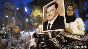 Woman supporter holds a poster of Hosni Mubarak in central Cairo
