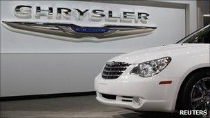A Chrysler Sebring sits in front of the Chrysler logo