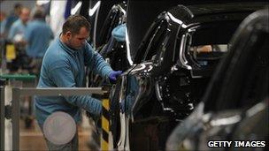 A factory worker works on a car in a BMW plant in Leipzig
