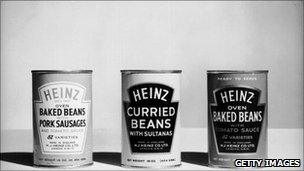 Three classic tins of Heinz beans in a black and white photograph
