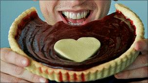 man bites heart shaped pie