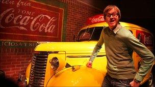 Alex Riley in front of an old Coca-Cola car