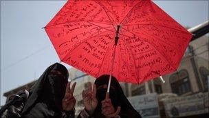 Women holding an umbrella attends an anti-government in Sanaa, 30 May 2011