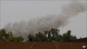 A smoke plume rises into the sky over Tripoli, Libya, following an air strike.