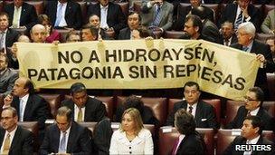 Opposition deputies hold up a placard in protest against the dam during Chile"s President Sebastian Pinera's annual address at the national congress building in Valparaiso city on 21 May, 2011
