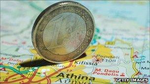 A euro coin on a map of Greece
