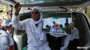Man said to be friend of Col Gaddafi holds picture of grandchild Libyan government says was killed in the Sorman raid