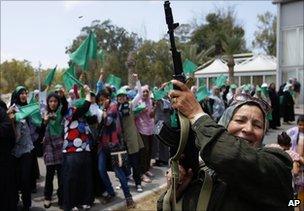 In this photo taken on a government-organised tour, a Libyan woman fires in the air during a graduation ceremony on Sunday 26 June 2011