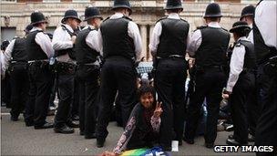 A person makes a peace sign as police surround protesters on Whitehall