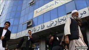 Afghans walk past a branch of the Kabul Bank (file photo)