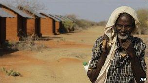A Somali refugee and goat herder walks past unoccupied refugee housing at Ifo II